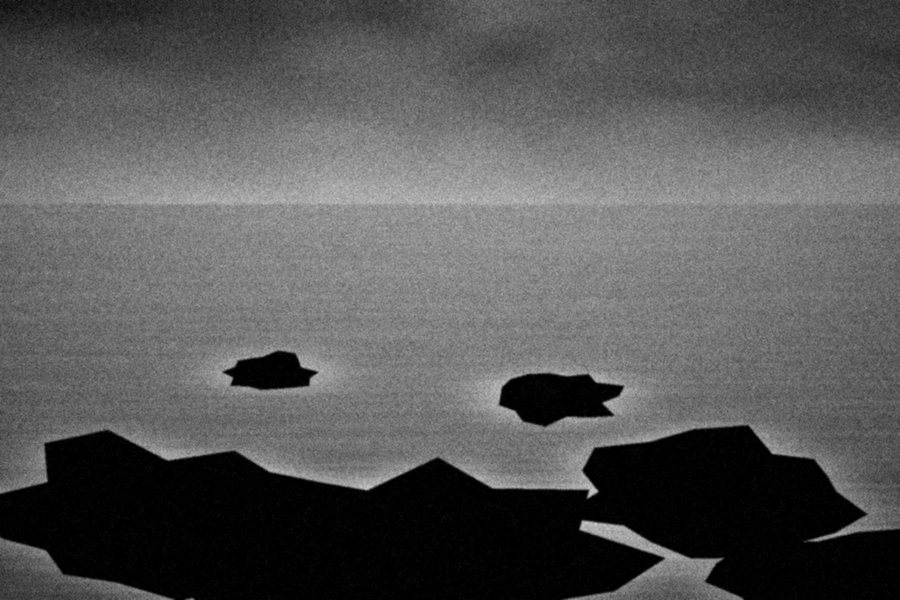 Dark rocks standing in surf turned to mist by a long exposure